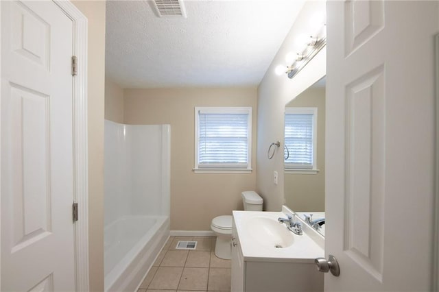 bathroom with tile patterned flooring, vanity, a textured ceiling, and toilet