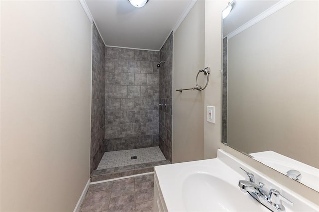 bathroom featuring ornamental molding, vanity, tile patterned flooring, and a tile shower