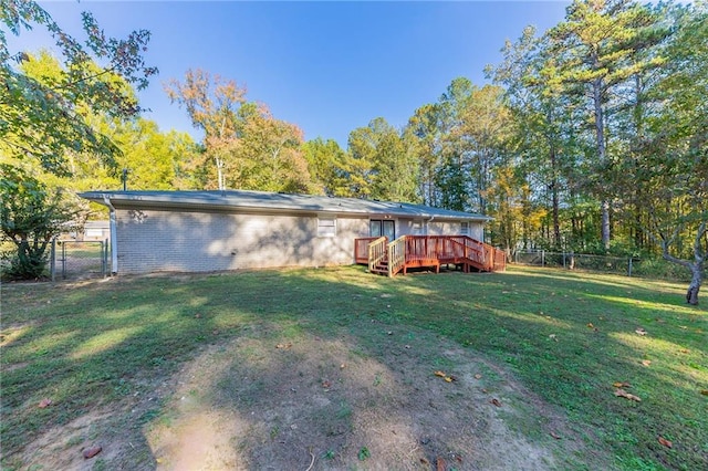 rear view of property featuring a yard and a deck