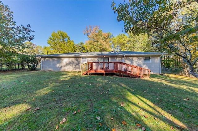 back of property with a wooden deck and a lawn