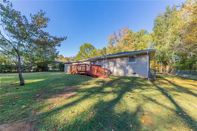 back of property with a yard and a wooden deck