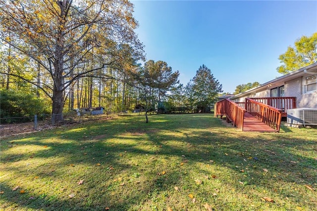 view of yard featuring central AC and a deck