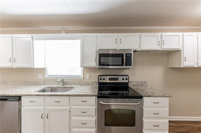 kitchen featuring white cabinets, sink, appliances with stainless steel finishes, and ornamental molding