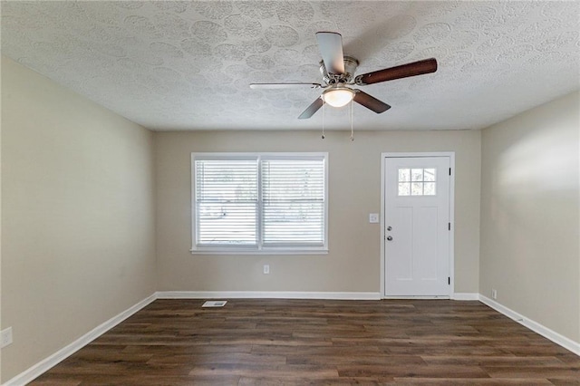 entryway featuring dark wood-type flooring, ceiling fan, and a textured ceiling