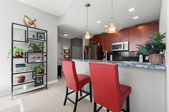 400 W Peachtree St NW Unit 3611, Atlanta, GA 30308 - kitchen featuring stainless steel appliances, backsplash, a peninsula, dark stone countertops, and pendant lighting