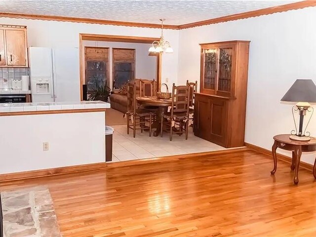 307 Little Hickory Ln, Woodstock, GA 30189 - dining area featuring light wood-style floors, a chandelier, crown molding, and a textured ceiling