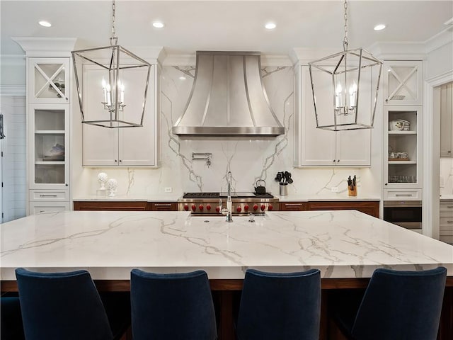 10155 Cedar Ridge Dr, Milton, GA 30004 - kitchen with a chandelier, custom range hood, stainless steel oven, light stone counters, and backsplash