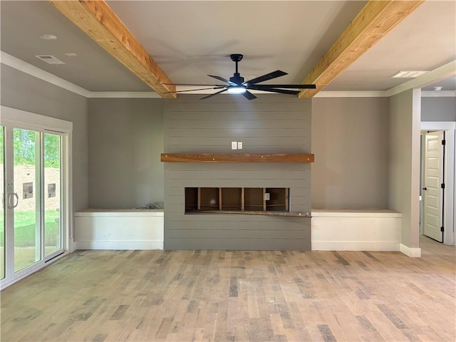 unfurnished living room with a ceiling fan, beam ceiling, a large fireplace, and wood finished floors