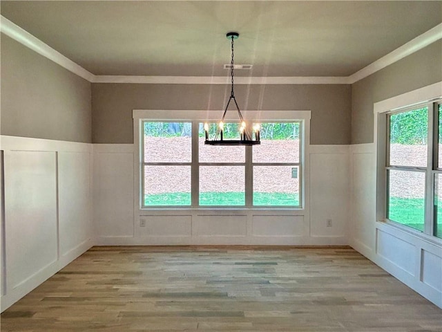 unfurnished dining area with a decorative wall and ornamental molding