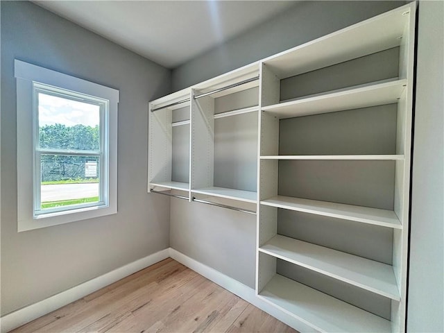 walk in closet with wood finished floors