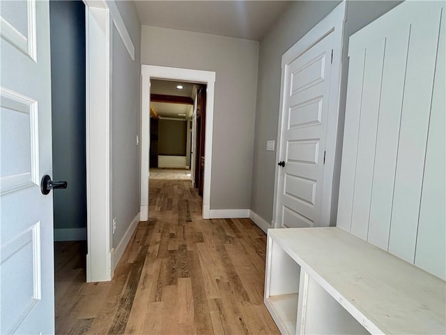 corridor with light wood-style floors and baseboards