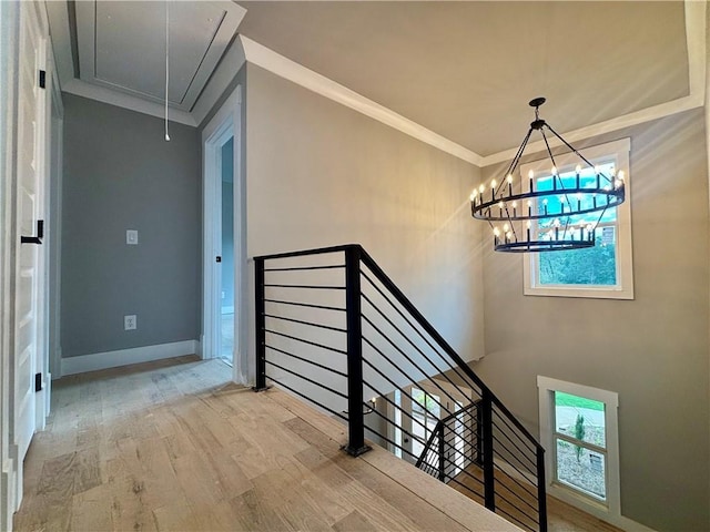 interior space featuring baseboards, a notable chandelier, ornamental molding, and wood finished floors