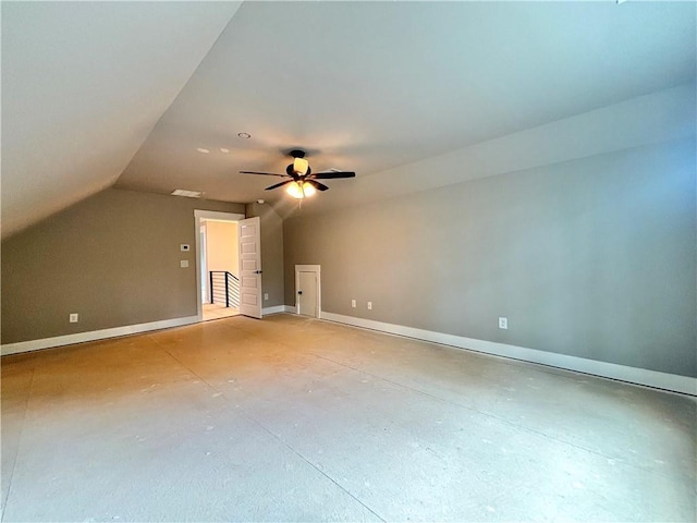 bonus room featuring lofted ceiling, baseboards, a ceiling fan, and concrete floors