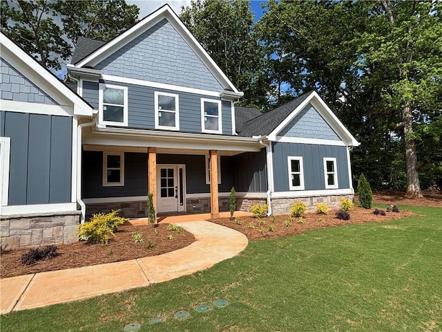 view of front facade featuring a porch, a front lawn, and board and batten siding
