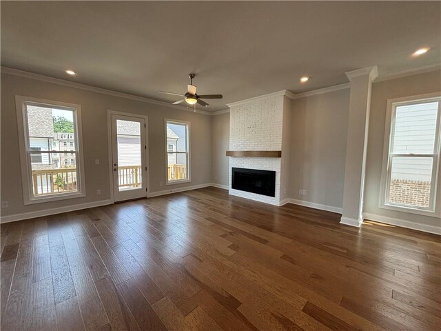 unfurnished living room featuring ceiling fan, ornamental molding, dark hardwood / wood-style floors, and a brick fireplace