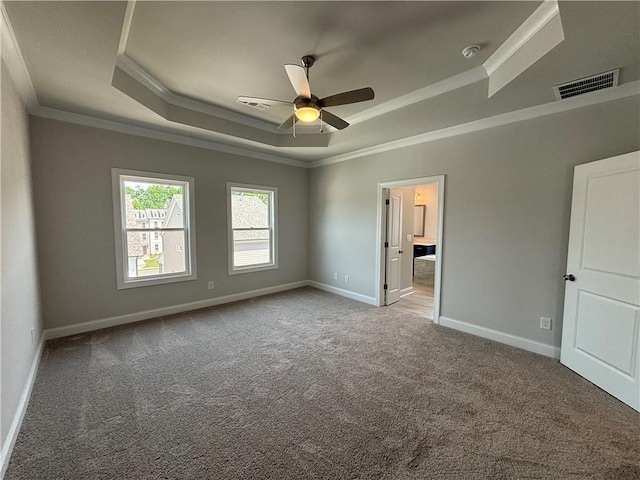 unfurnished room with ceiling fan, light colored carpet, ornamental molding, and a raised ceiling