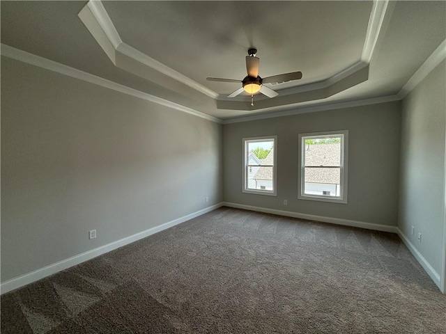 carpeted empty room with ceiling fan, ornamental molding, and a tray ceiling