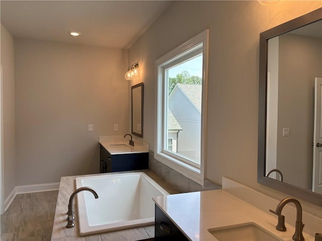 bathroom featuring vanity and a washtub