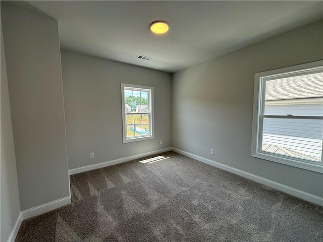 unfurnished room with dark carpet