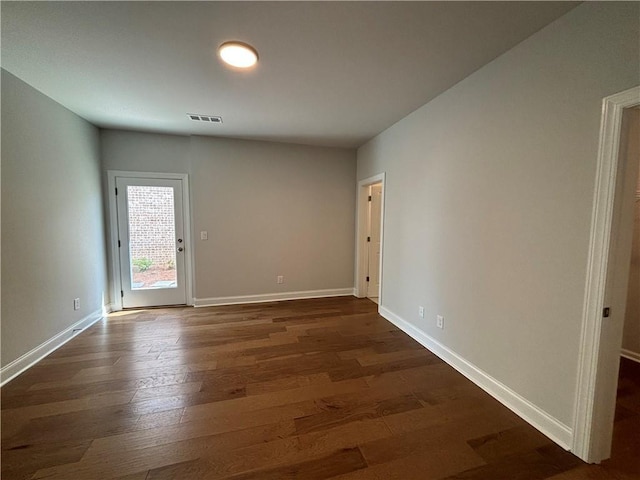 unfurnished room featuring dark wood-type flooring