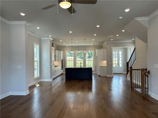 unfurnished living room featuring dark hardwood / wood-style flooring, sink, crown molding, and ceiling fan