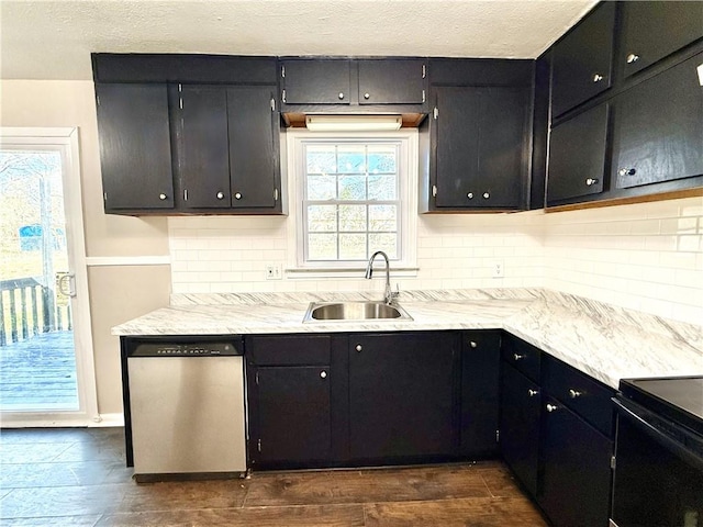 kitchen with dishwasher, a sink, dark wood finished floors, and dark cabinets