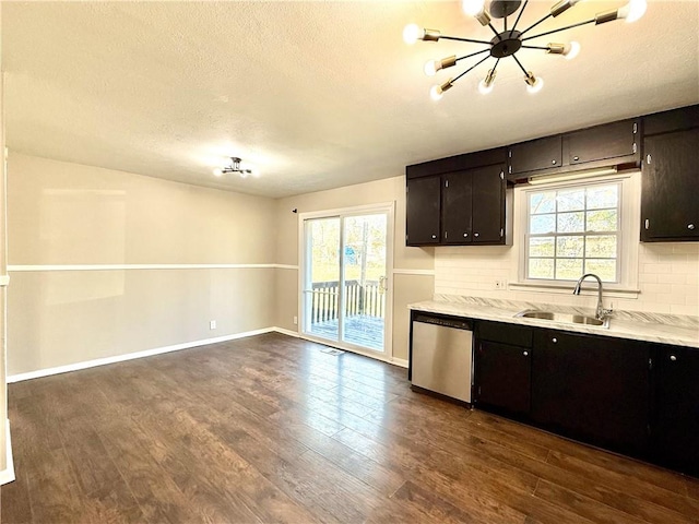 kitchen with dishwasher, dark wood-style flooring, a sink, light countertops, and backsplash