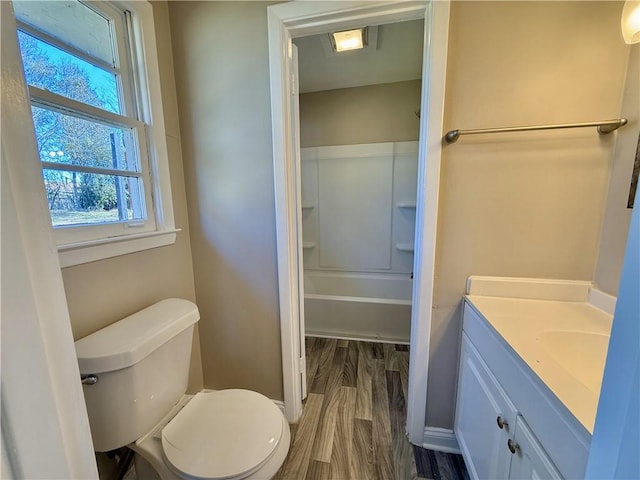 full bathroom featuring toilet, tub / shower combination, wood finished floors, and vanity