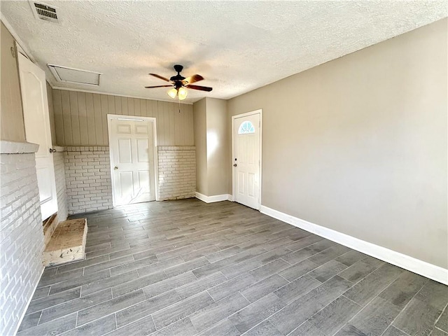 interior space featuring dark wood finished floors, visible vents, a ceiling fan, a textured ceiling, and baseboards