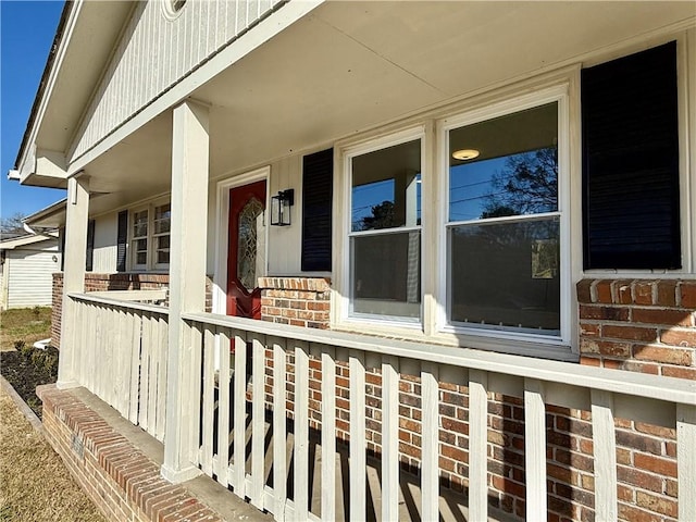 property entrance with brick siding and a porch