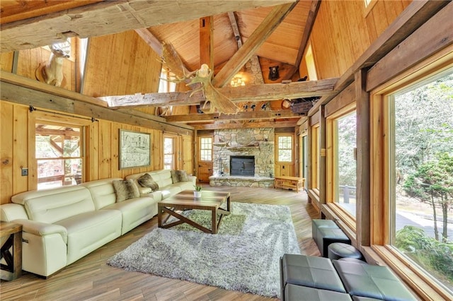 living room featuring plenty of natural light, a fireplace, wood-type flooring, and wood walls