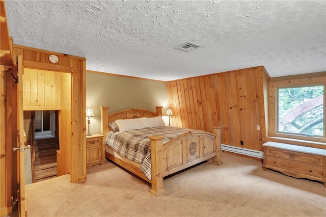 bedroom with a textured ceiling, light colored carpet, and baseboard heating