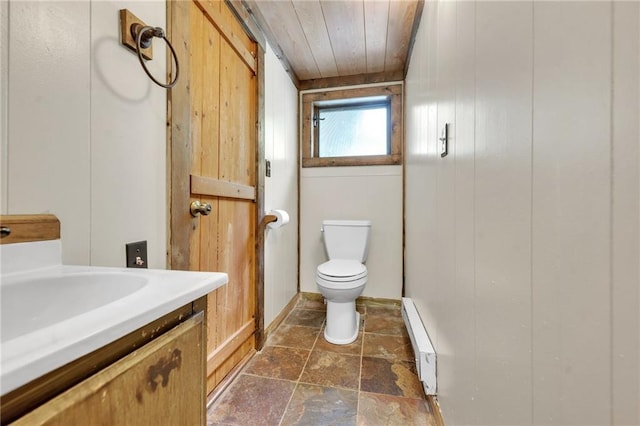 bathroom with tile flooring, wooden ceiling, baseboard heating, vanity, and toilet