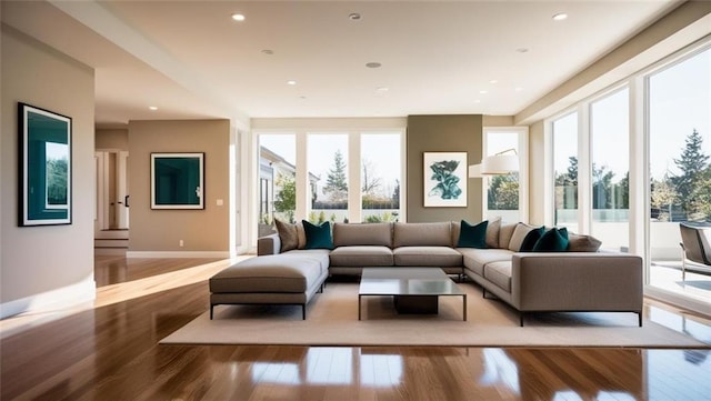 living room featuring baseboards, light wood-style flooring, and recessed lighting