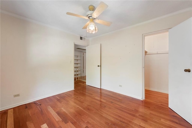 270 Lakemoore Dr NE Unit B, Atlanta, GA 30342 - unfurnished bedroom with ornamental molding, wood finished floors, a closet, a walk in closet, and a ceiling fan