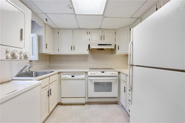 270 Lakemoore Dr NE Unit B, Atlanta, GA 30342 - kitchen with white appliances, a paneled ceiling, stacked washing machine and dryer, under cabinet range hood, and light countertops