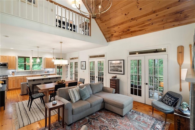 367 Windflower Dr, Big Canoe, GA 30143 - living room with french doors, light wood finished floors, a chandelier, and high vaulted ceiling