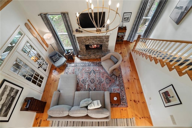 367 Windflower Dr, Big Canoe, GA 30143 - living room featuring a chandelier, hardwood / wood-style flooring, a stone fireplace, and a towering ceiling