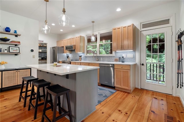 367 Windflower Dr, Big Canoe, GA 30143 - kitchen with appliances with stainless steel finishes, backsplash, light wood finished floors, a breakfast bar, and recessed lighting