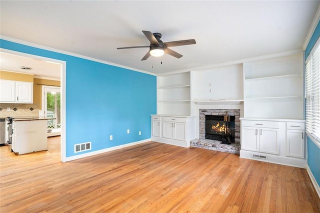 890 Oriole Ln SE, Marietta, GA 30067 - unfurnished living room featuring a ceiling fan, baseboards, light wood-type flooring, a stone fireplace, and crown molding