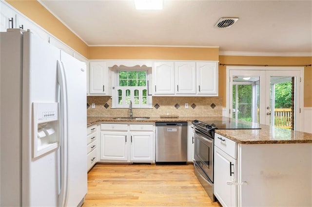 890 Oriole Ln SE, Marietta, GA 30067 - kitchen with appliances with stainless steel finishes, a peninsula, french doors, ornamental molding, and white cabinetry