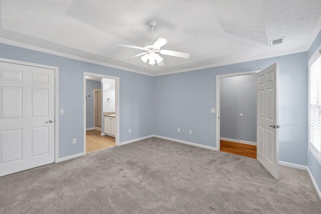 unfurnished bedroom with visible vents, ornamental molding, and light carpet