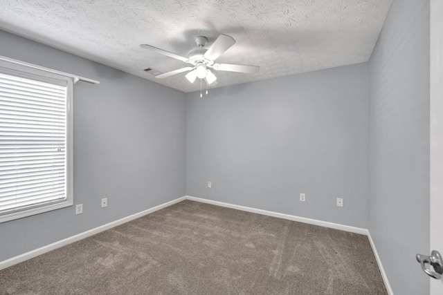 spare room featuring baseboards, ceiling fan, carpet flooring, and a textured ceiling