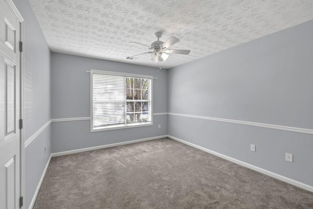 spare room with carpet floors, a textured ceiling, ceiling fan, and baseboards