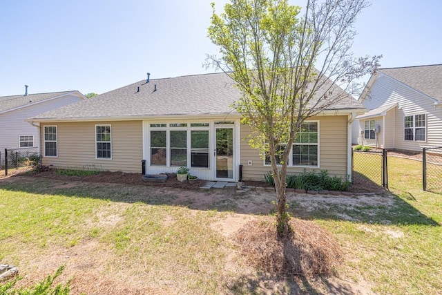back of property featuring a gate, fence, and a yard