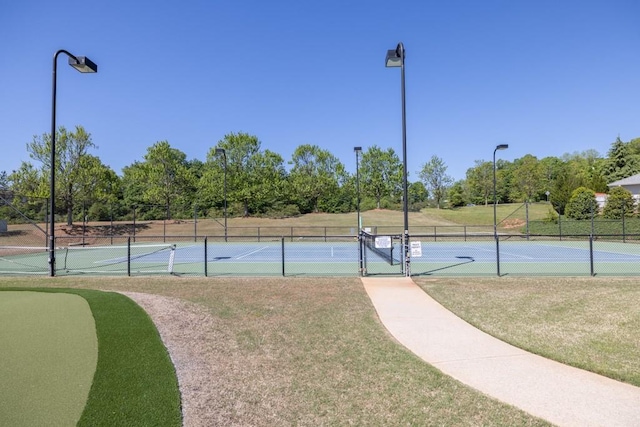 view of sport court featuring fence and a yard