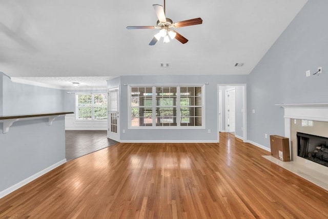 unfurnished living room featuring a fireplace with flush hearth, baseboards, a ceiling fan, and wood finished floors