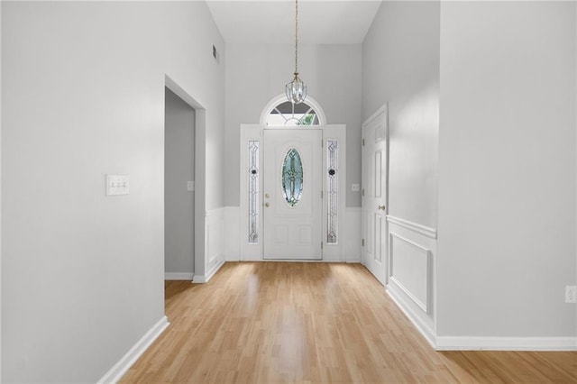 4801 Devonhurst Way, Powder Springs, GA 30127 - entryway with light wood-style floors, a high ceiling, wainscoting, and a decorative wall