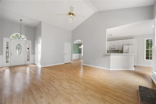 4801 Devonhurst Way, Powder Springs, GA 30127 - unfurnished living room with high vaulted ceiling, a ceiling fan, arched walkways, light wood-type flooring, and baseboards