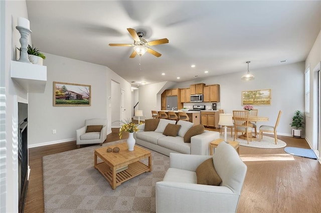 living room featuring ceiling fan and light wood-type flooring